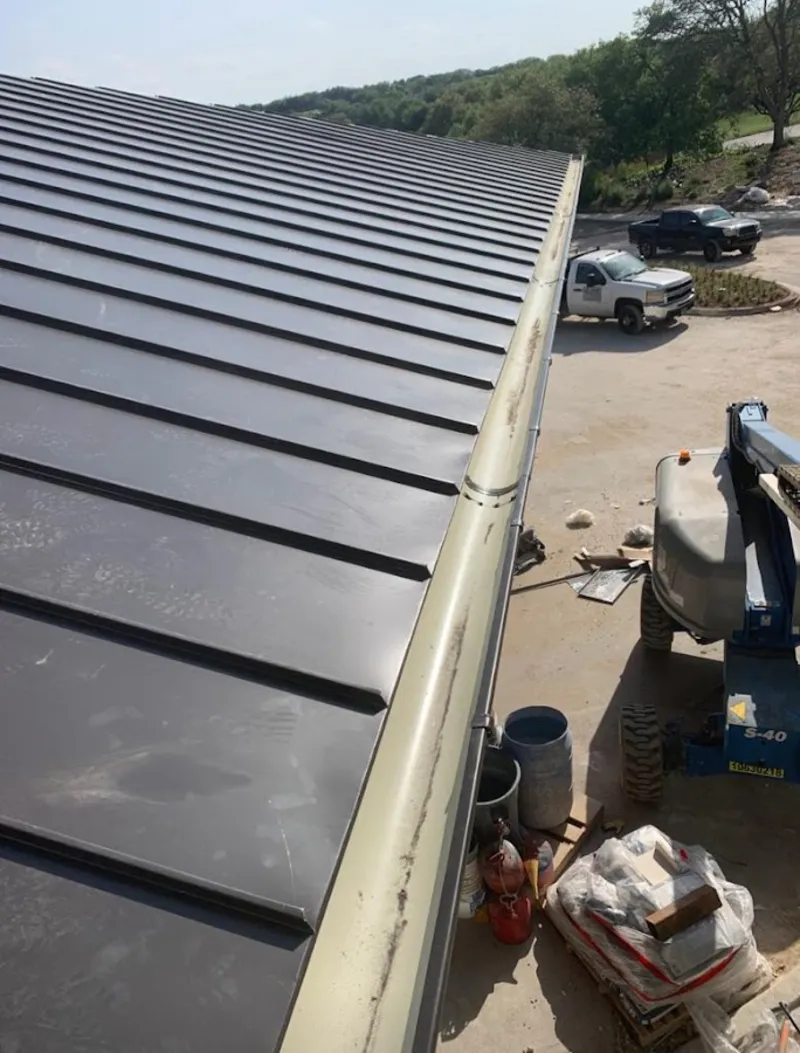 Standing seam panel and gutter detail on a metal roofing jobsite in Roscoe